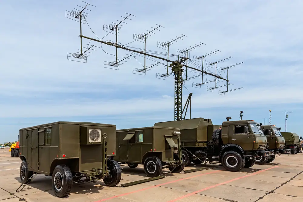 Militärische LKWs und eine große Radaranlage als technische Ausrüstung im Fachdienst der Bundeswehr.