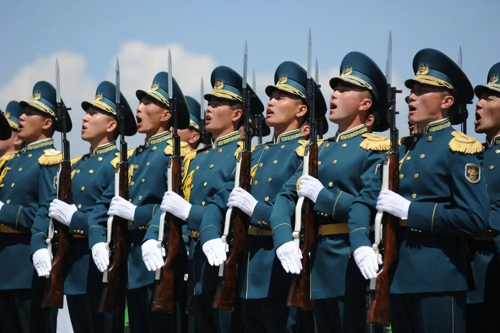 Soldaten in Paradeuniform stehen in einer Reihe bei einer Zeremonie und halten Gewehre mit Bajonetten.