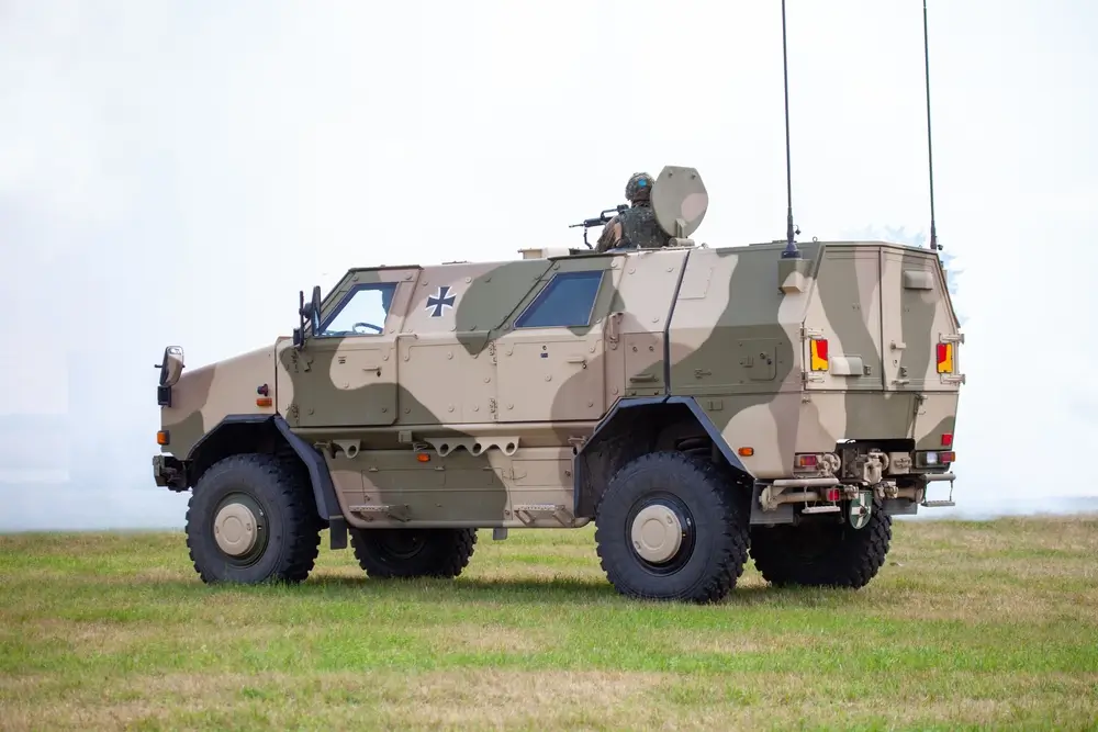 Gepanzertes Militärfahrzeug der Bundeswehr auf einer Wiese während einer Übung im freiwilligen Wehrdienst.