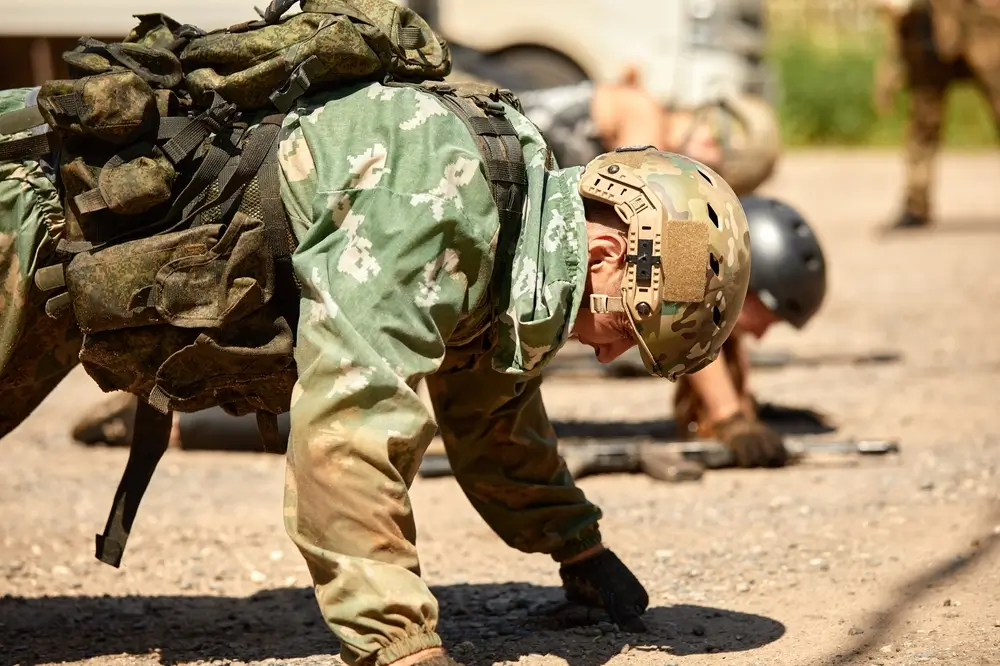 Bundeswehr-Rekruten bei sportlichen Übungen in Uniform und Ausrüstung während der militärischen Grundausbildung.