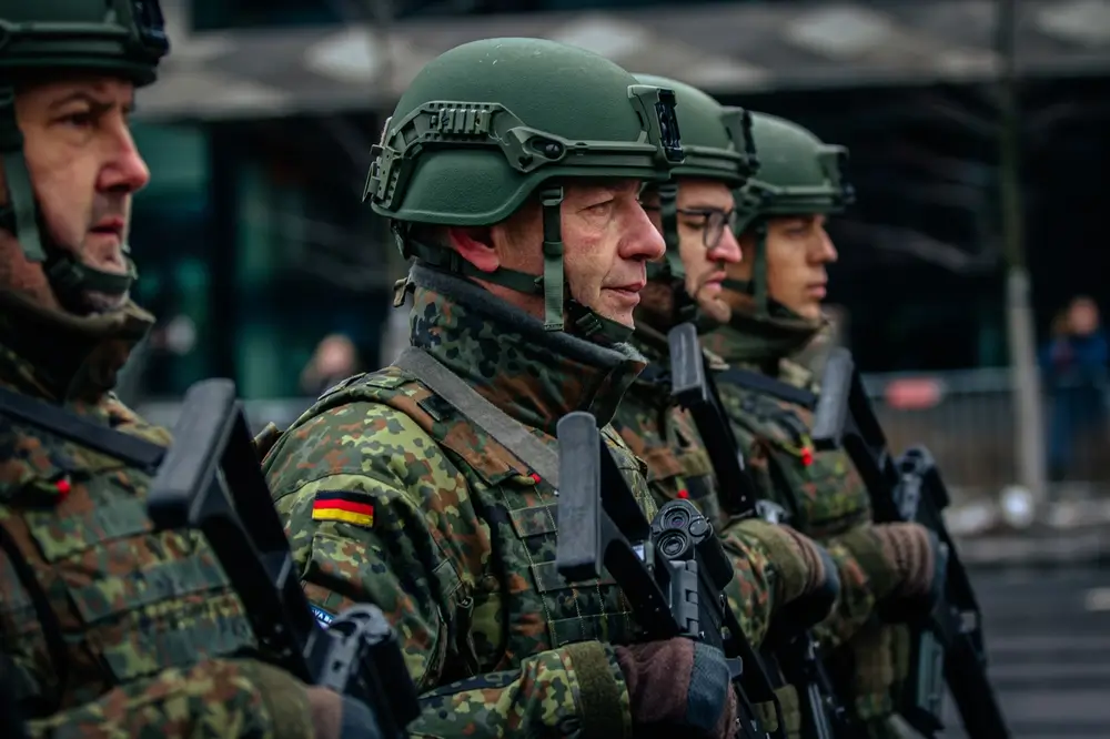 Eine Soldatengruppe der Bundeswehr in Flecktarn-Uniform mit Ausrüstung bei einer militärischen Ausbildung im Freien.