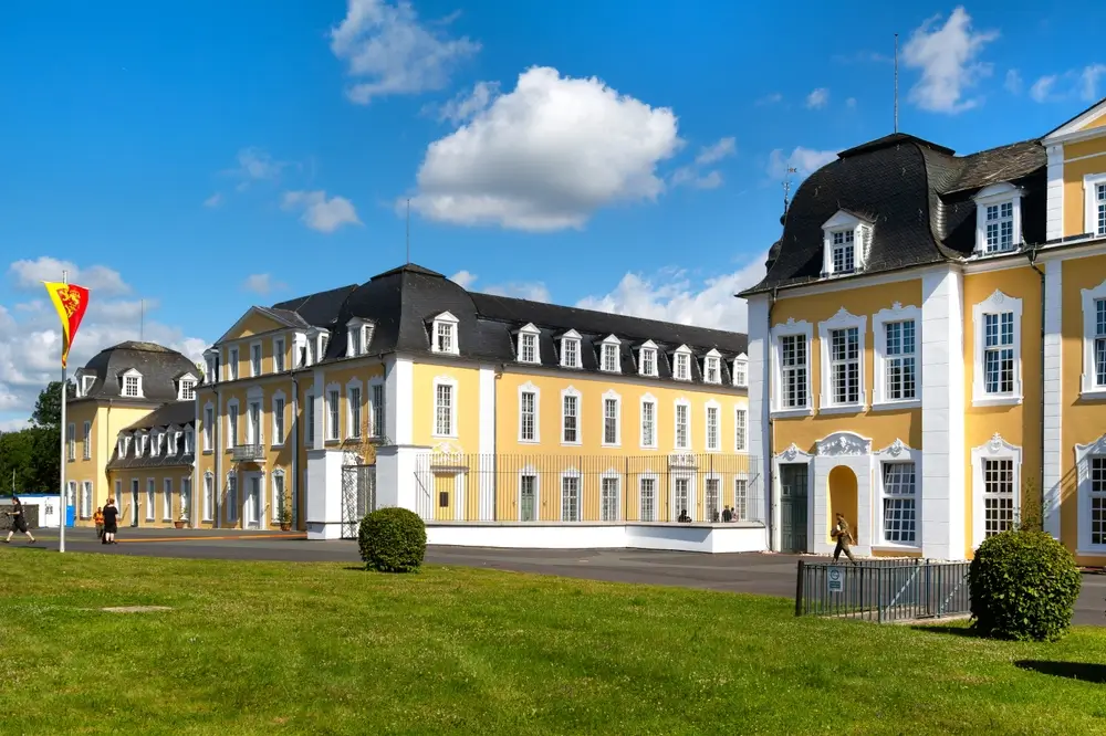 Gelbe barocke Gebäude einer Bundeswehr-Kaserne mit Flagge auf einer Militärbasis in Deutschland.
