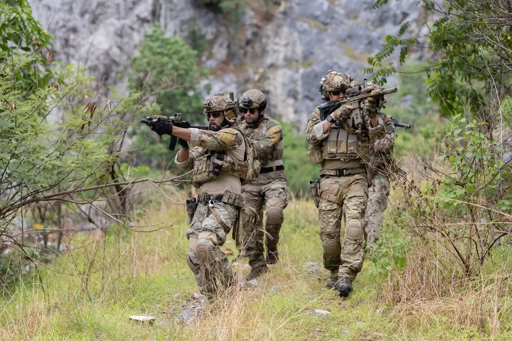 Soldaten in Tarnkleidung bei einer taktischen militärischen Übung und Ausbildung im Gelände.